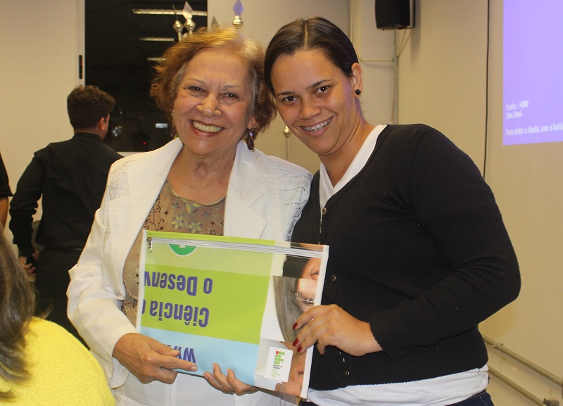 A conferencista da abertura da Semana, professora Walderês Nunes Loureiro, recebeu uma lembrança do IFG Aparecida de Goiânia, das mãos da aluna Cristiane Melo e Silva, do curso de Pedagogia Bilíngue